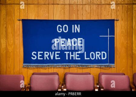 `Go in Peace Serve the Lord` written on Dark Blue Cloth with white cross on the right side, tassels all along the bottom of the cloth. Stock Vector